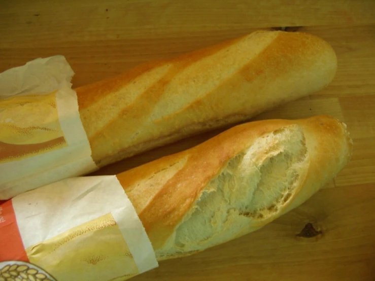 two loaves of bread in wrappers sit on a counter