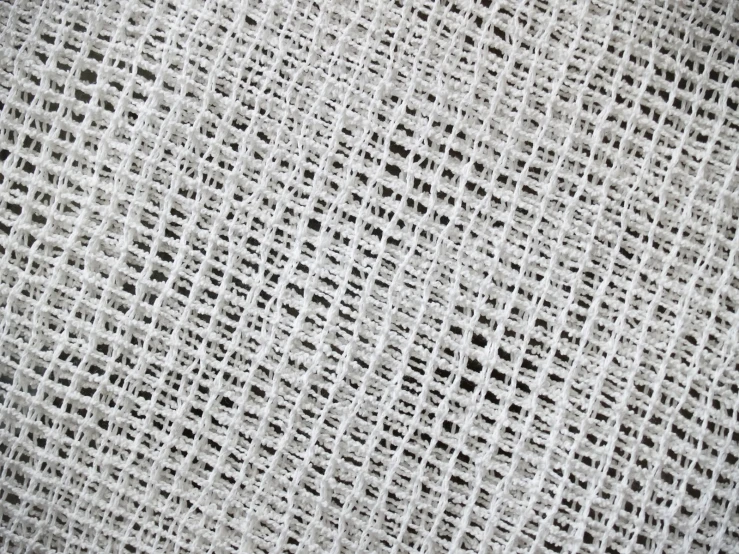 a white background with small squares of gray colored crocheted