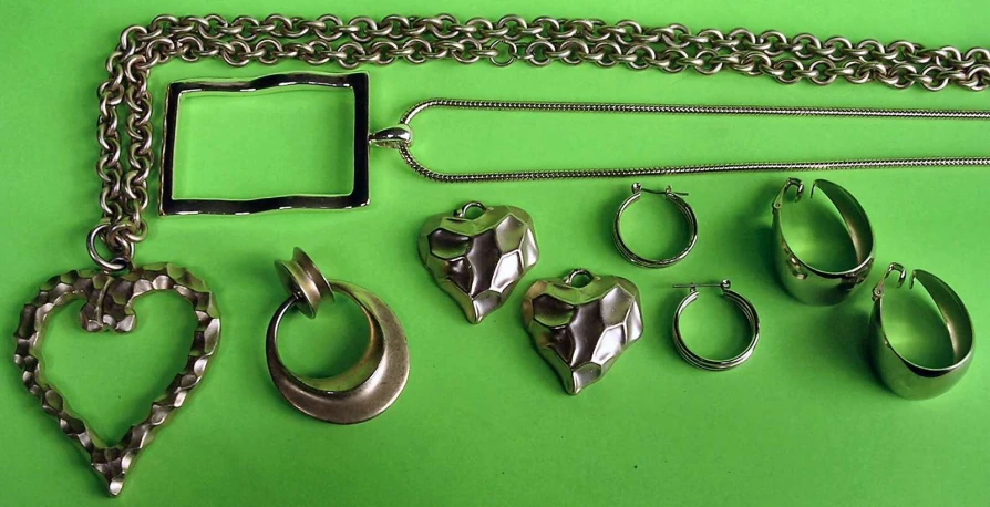 a group of silver items laying out on a green surface