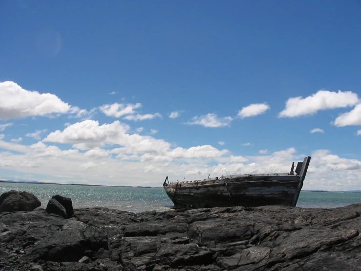 two boats are sitting on the rocky shore