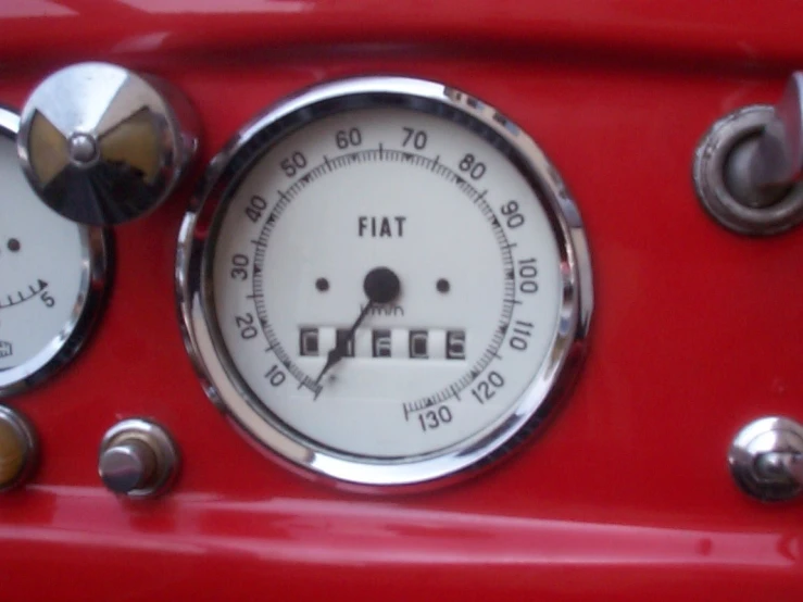 close up po of the gauge on a red motor vehicle