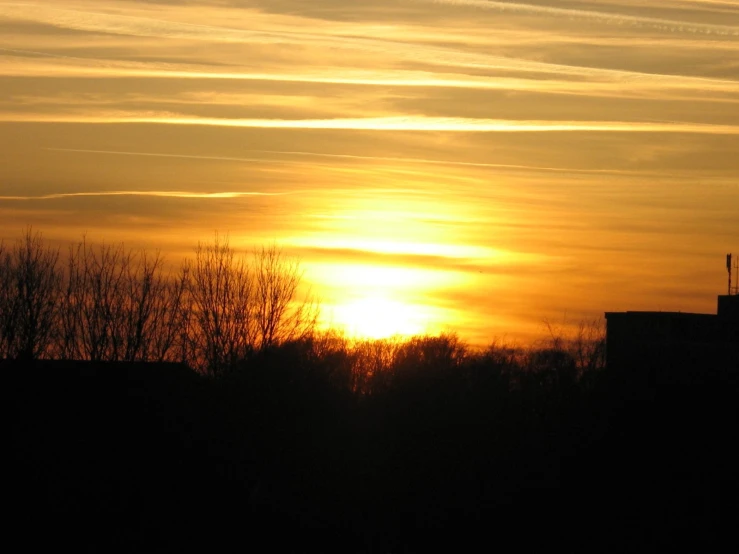 a sunset with a large building in the background