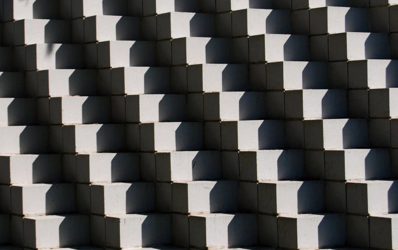 the shadow of square blocks against a wall