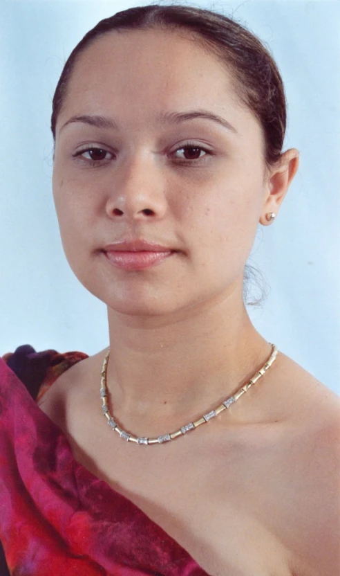 a young woman wearing a necklace and a red dress