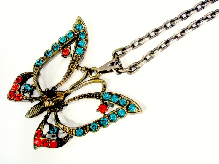 a fancy erfly pendant is displayed on a chain