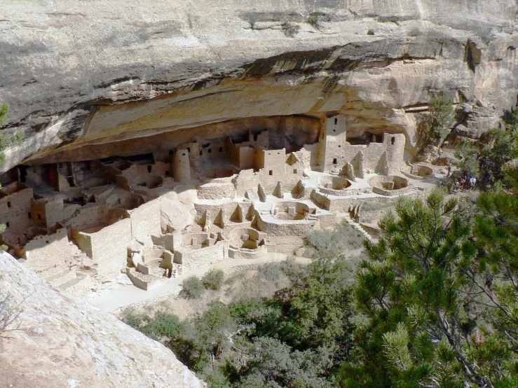 a cliff with a bunch of buildings and trees around it