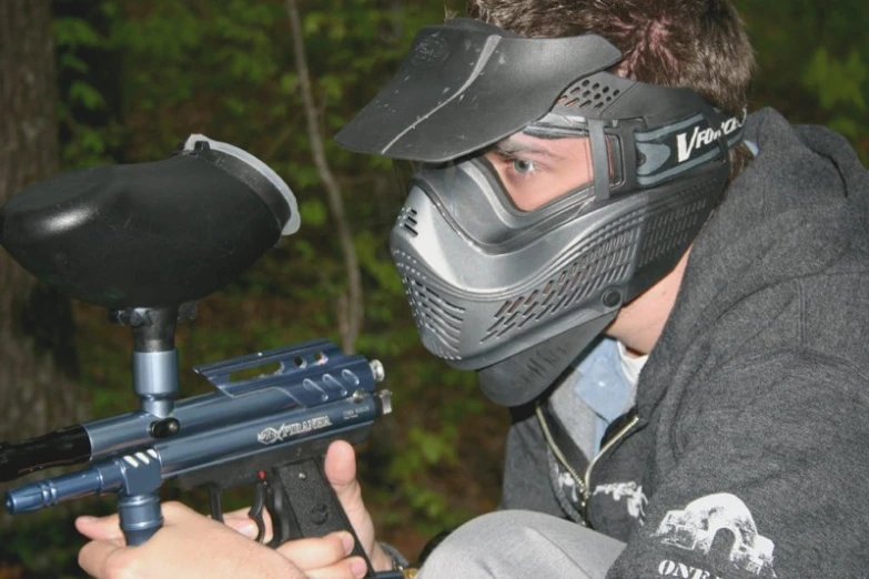 a person wearing a full mask and holding an automatic rifle