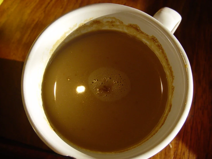 a cup filled with dark brown liquid on a table