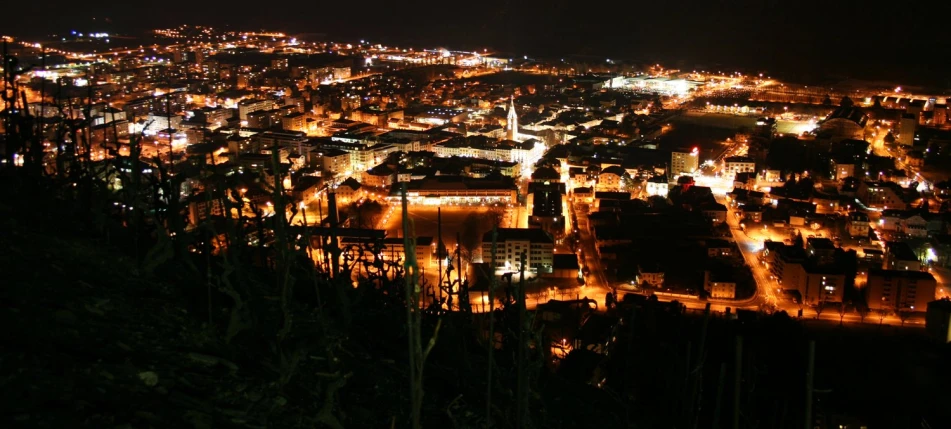 the town lights shine brightly against the nighttime sky