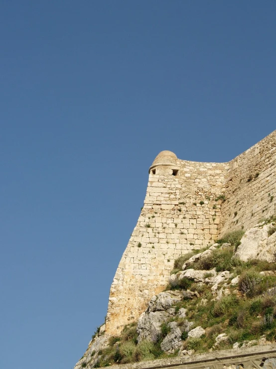 a large stone building is standing on top of a hill