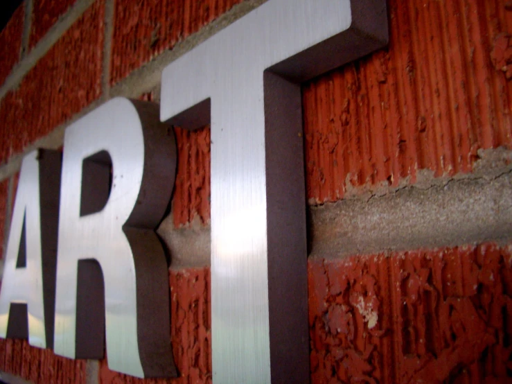 the number four sign is in metal against red bricks