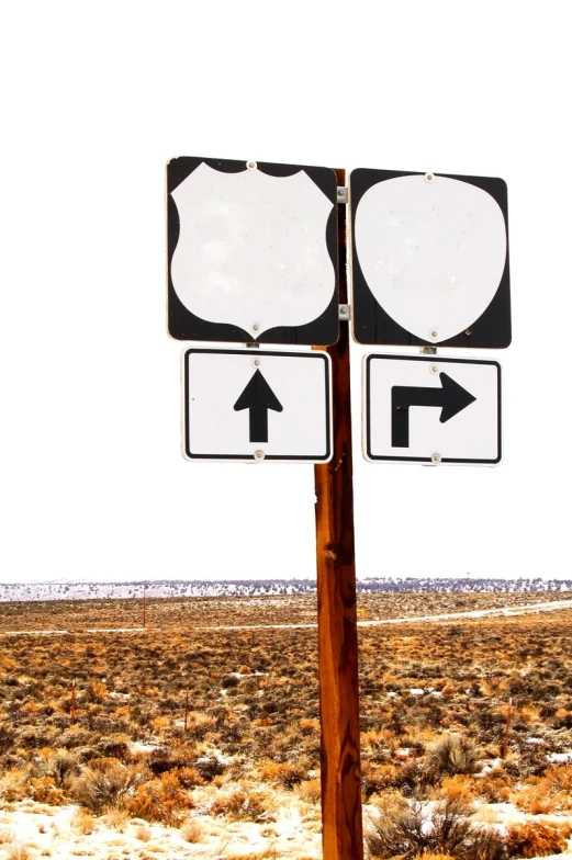 a couple of street signs sitting on top of a brown pole