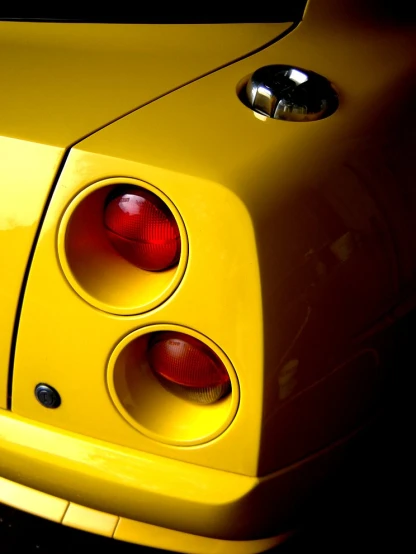 the taillights on the back of a yellow sports car