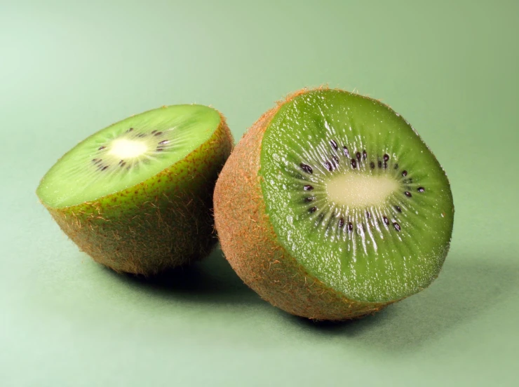 a sliced kiwi on a green background