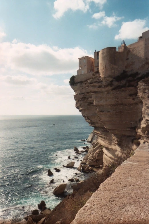 a large cliff has a long line of rocks