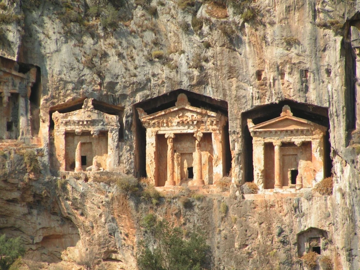 carved cave temples perched on the side of a mountain