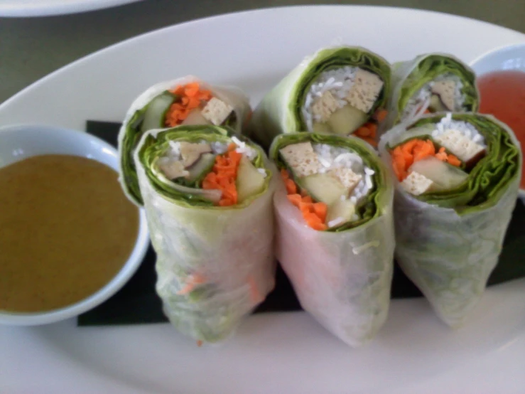 a plate with some rolls and dipping sauce