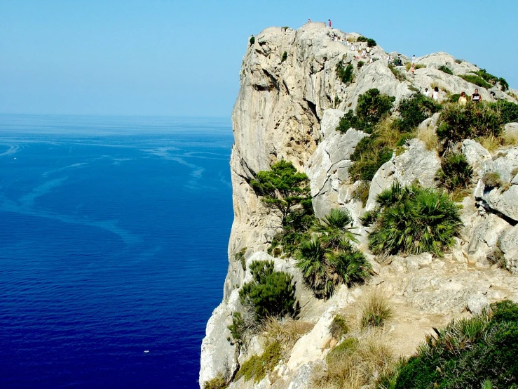 people are standing on top of an island on a mountain