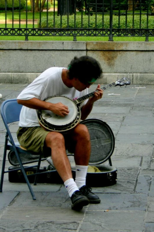 a man sitting on top of a chair holding a guitar