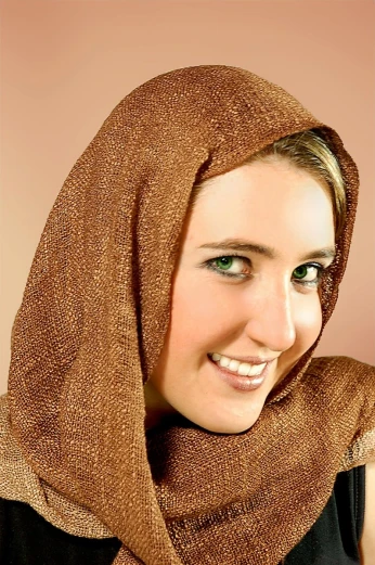 a woman wearing a brown scarf and smiling