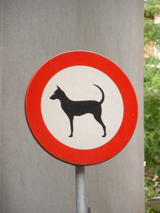 a red and white sign with black dog in it