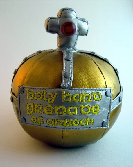 a metal object with yellow ball and writing