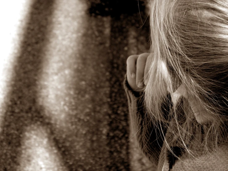 a little girl looking through the hair of someone