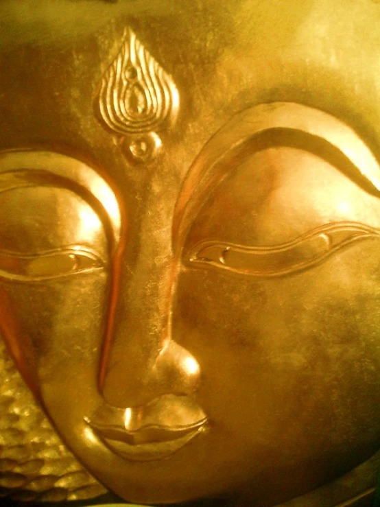 the face of the buddha statue in gilded gold