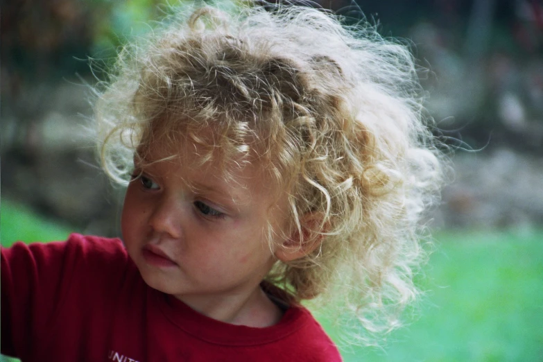 a child holding a frisbee on top of green grass