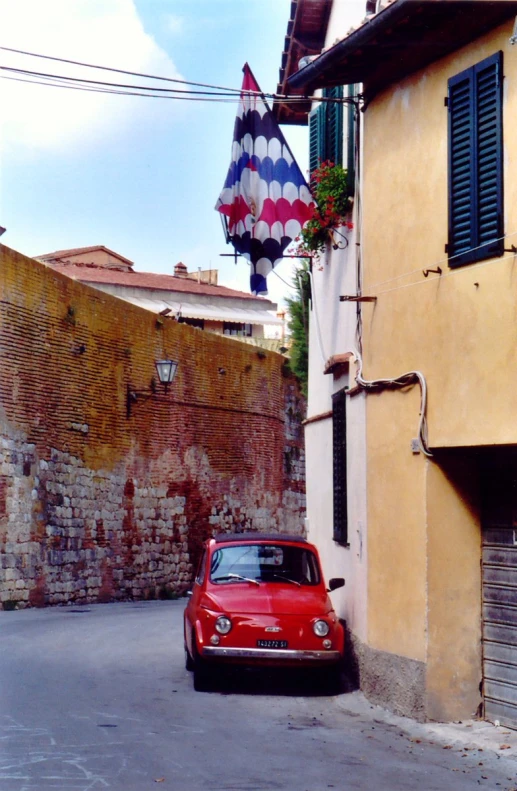 a car is parked on the side of a road in front of an old brick building