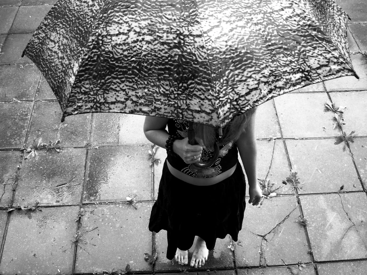 a woman is underneath an umbrella and standing outside