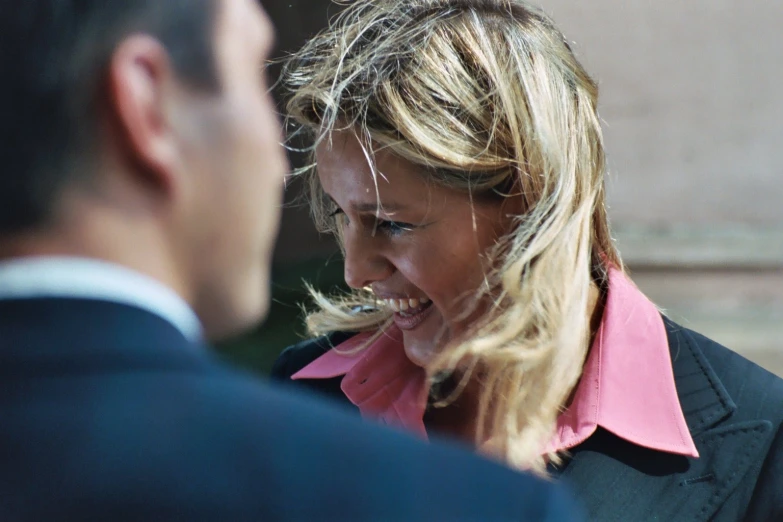 the woman smiles while talking to another man