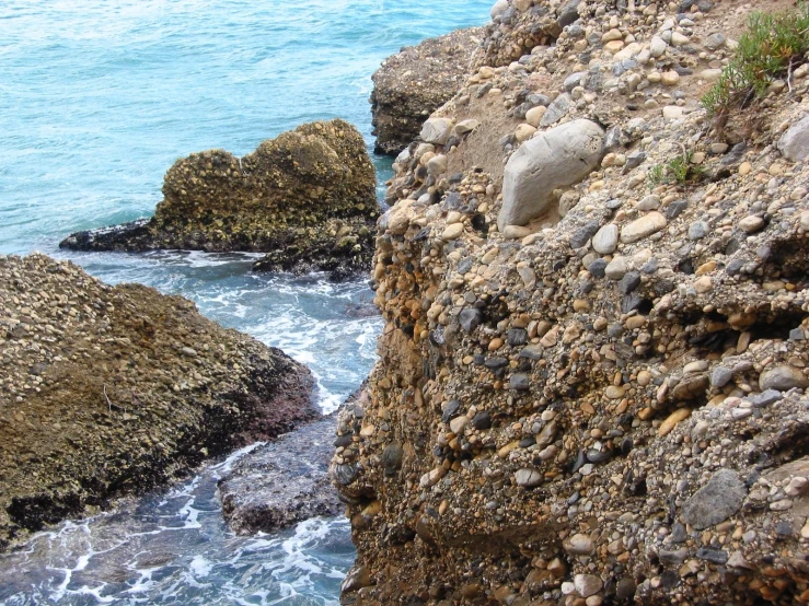 an ocean coast line with rocks in the foreground