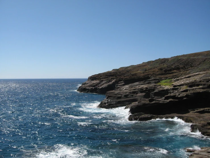 water running down the side of a cliff by the ocean