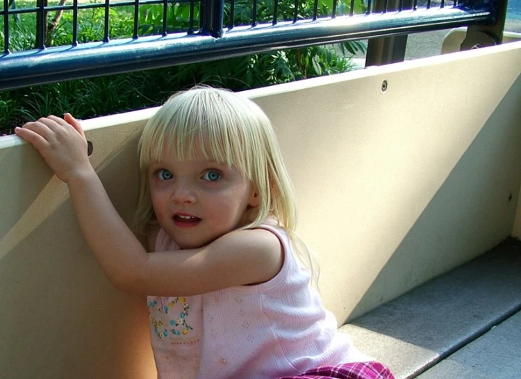 a little girl that is sitting on the ground