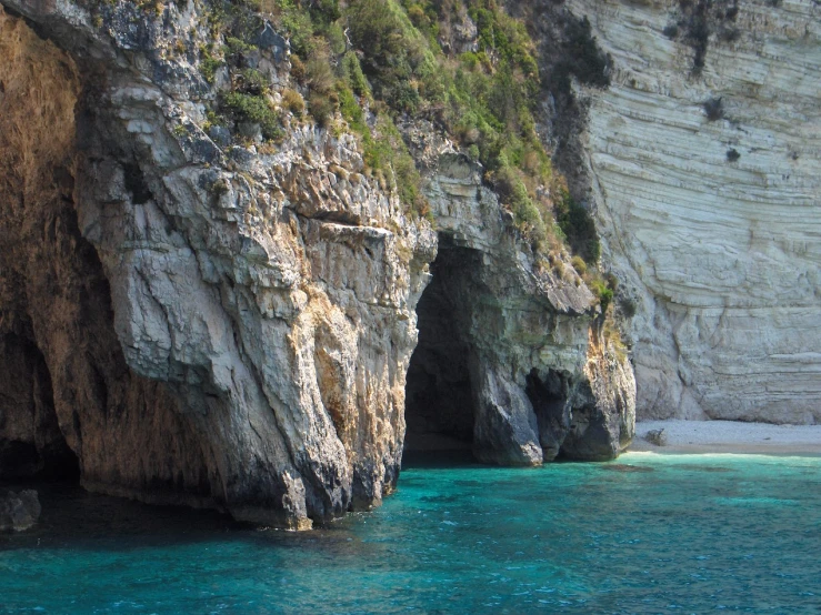 two large rock formation at the shore of a small body of water