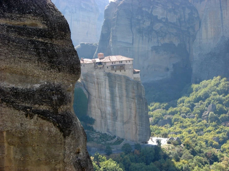 a view looking down on a small village in the mountains from a cliff