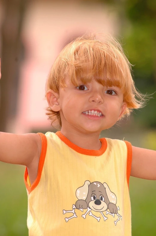 small blonde boy with red hair wearing a yellow shirt