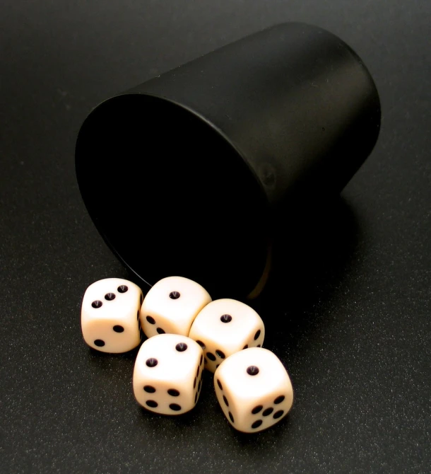 the six dice are on the table with a black cup
