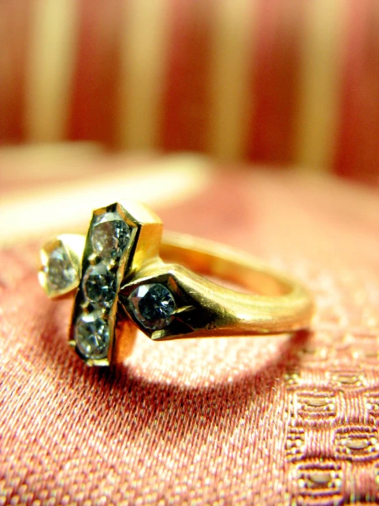 a gold ring with two diamond stones in the center