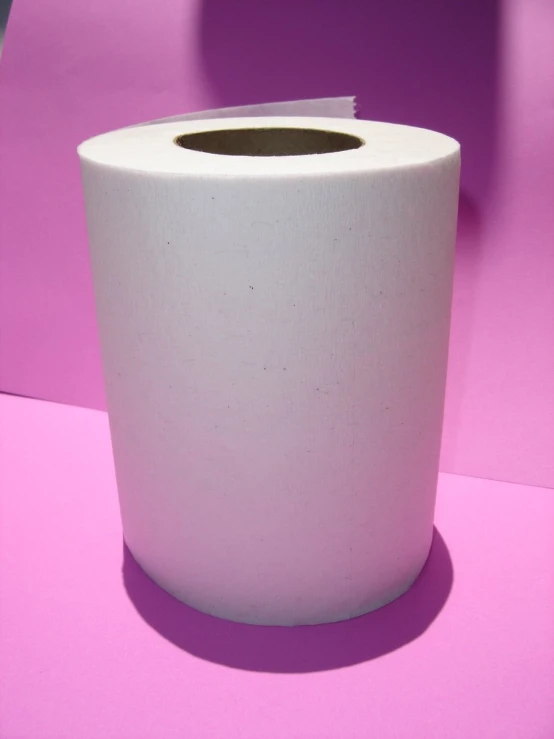 a roll of toilet paper sitting on top of a pink counter