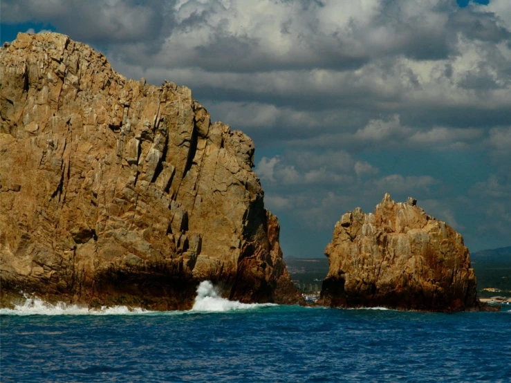 the rocks are being hed by the surf at sea