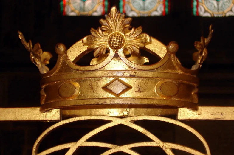 a gold crown sits against the iron bars of a building