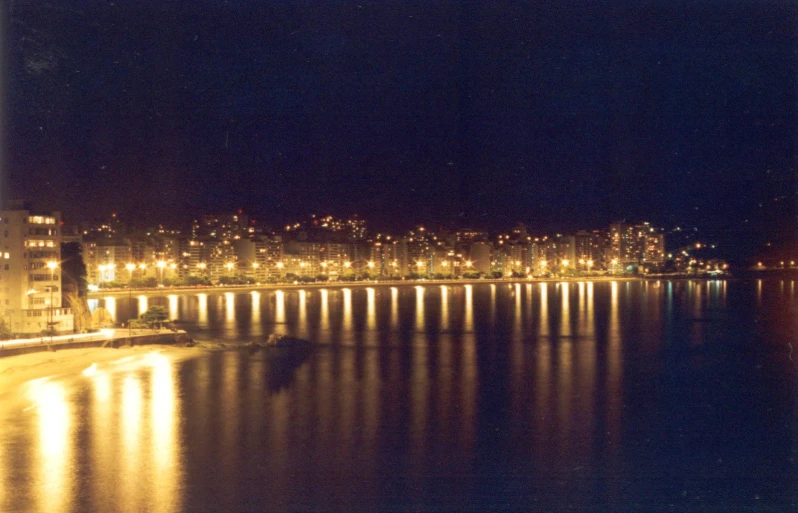 city lights shine above the water at night