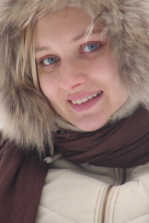 a girl in brown is smiling at the camera