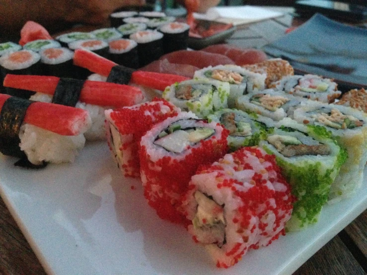 several kinds of sushi are displayed on a white plate