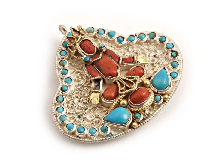 an intricately crafted brooch with many turquoise, red and gold jewels