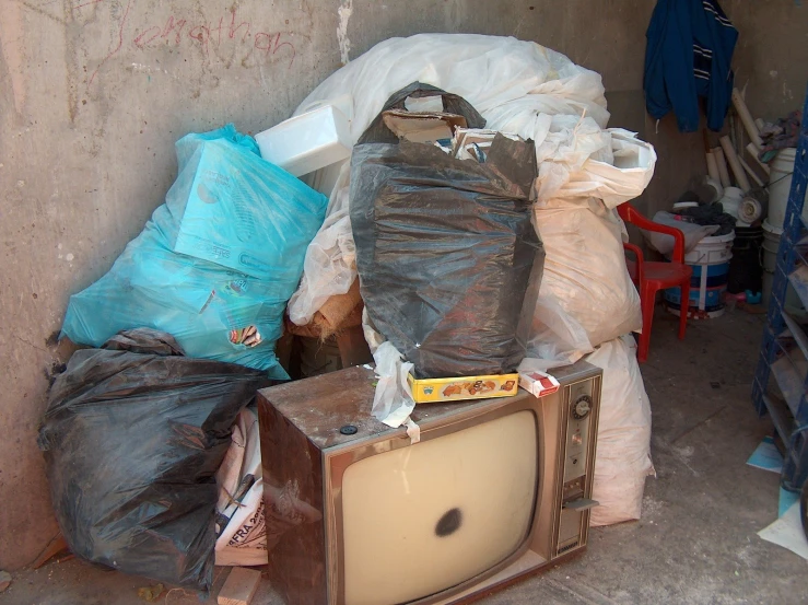 old television and bags of garbage in a warehouse