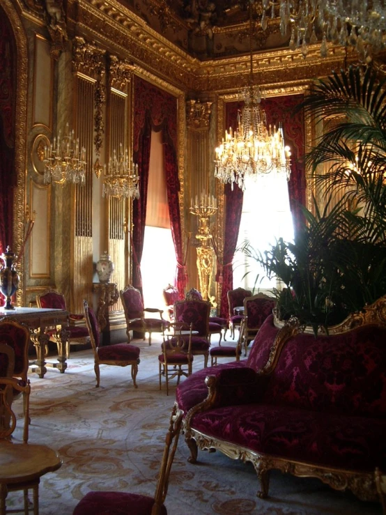 an elegant living room with chandelier and velvet furniture