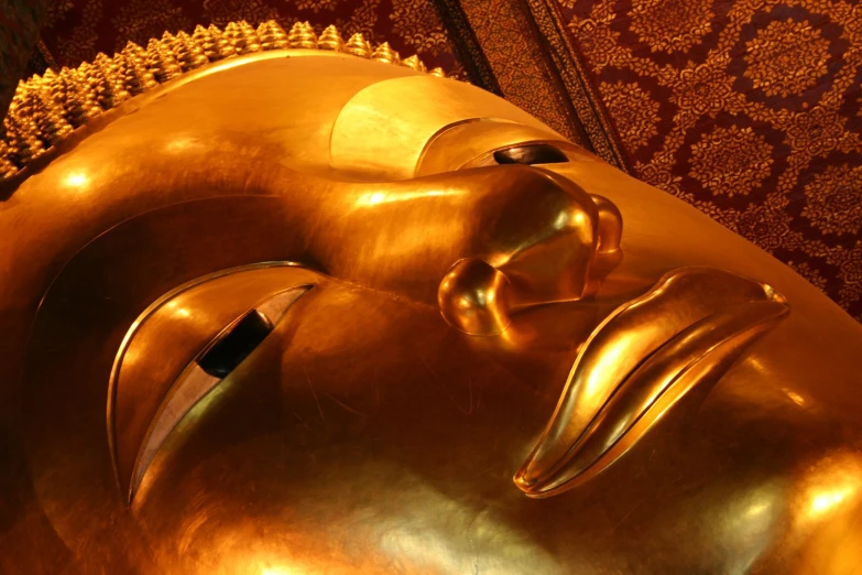 a golden buddha statue that is laying on the floor